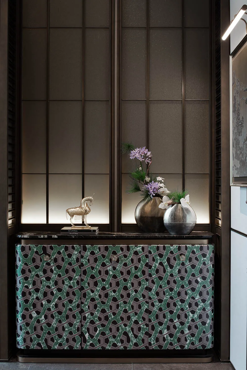 Warm and inviting room with a wooden cabinet, a vase of flowers, and natural light from a window