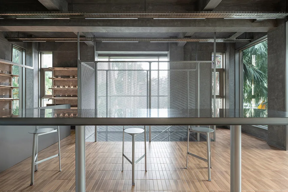 Warm and inviting kitchen dining space with a wooden floor, a counter with stools, a table, and chairs, and bottles on the counter