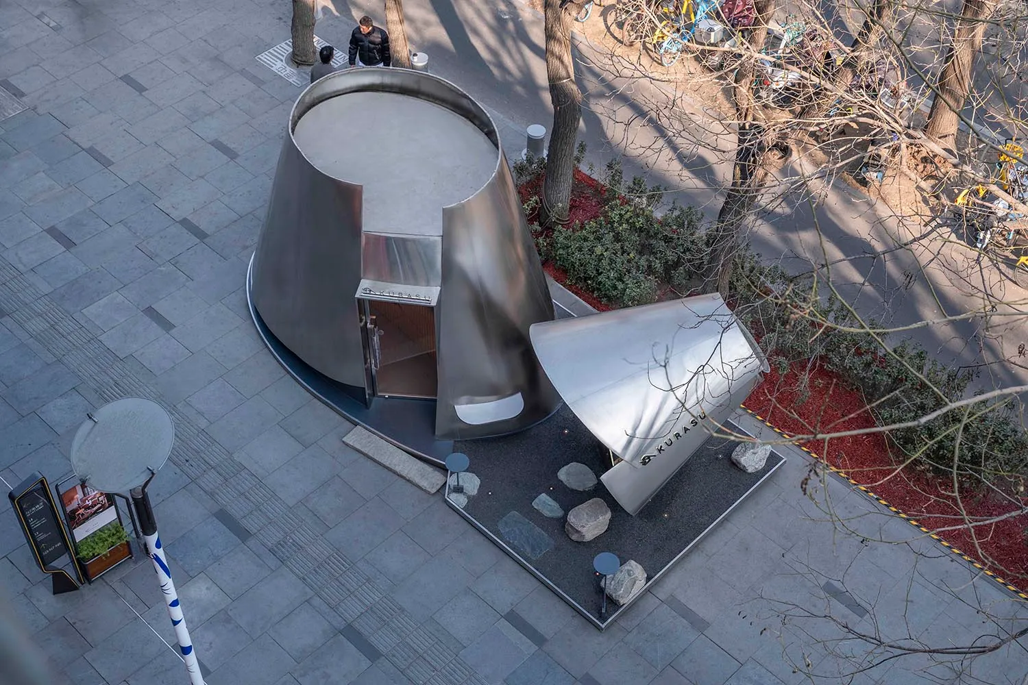 現代建築的照片，具有大型銀色穹頂和小型銀色穹頂，背景是紅磚牆和石牆