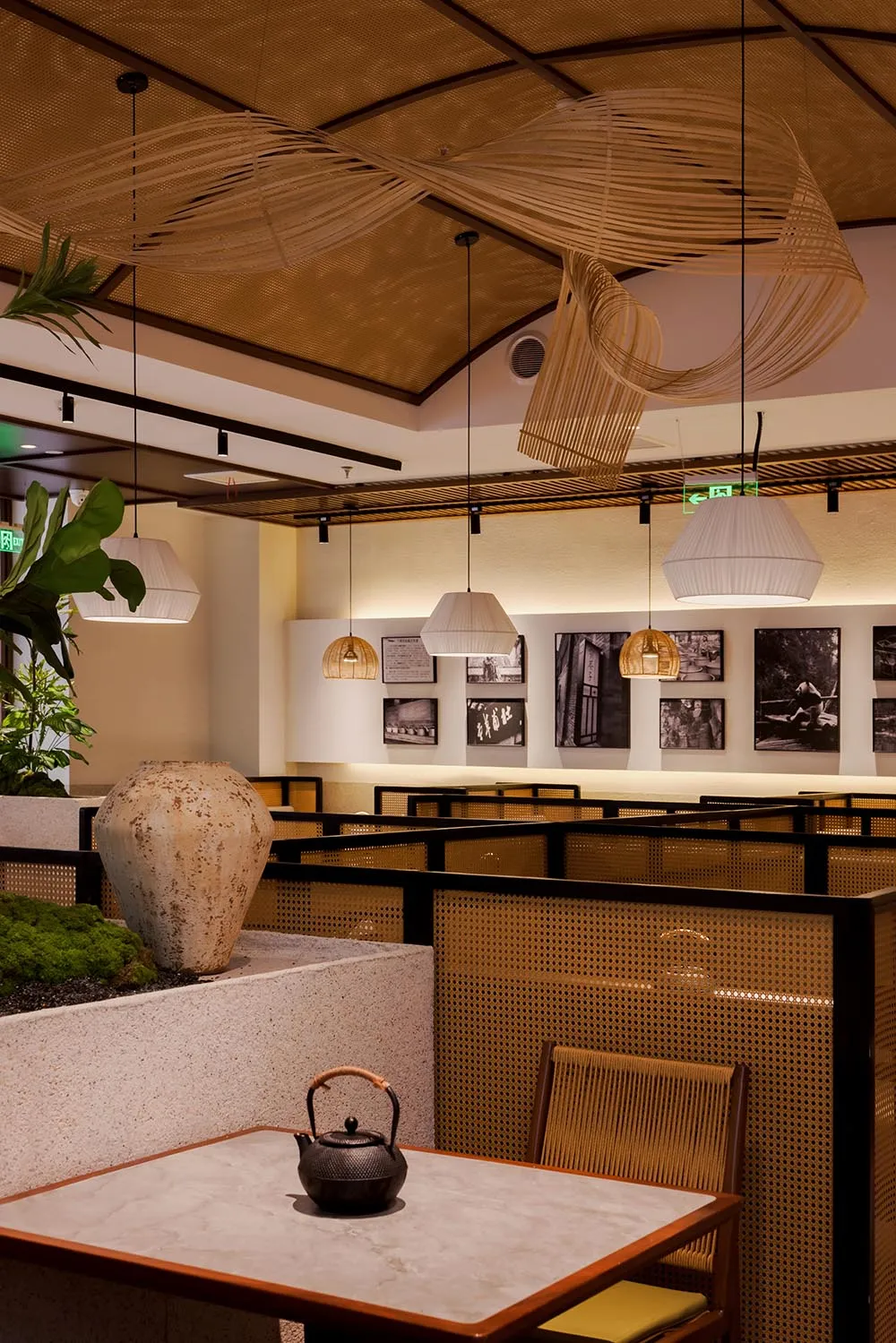 A modern restaurant with a warm atmosphere, featuring wood and metal elements, dim lighting, and comfortable seating areas