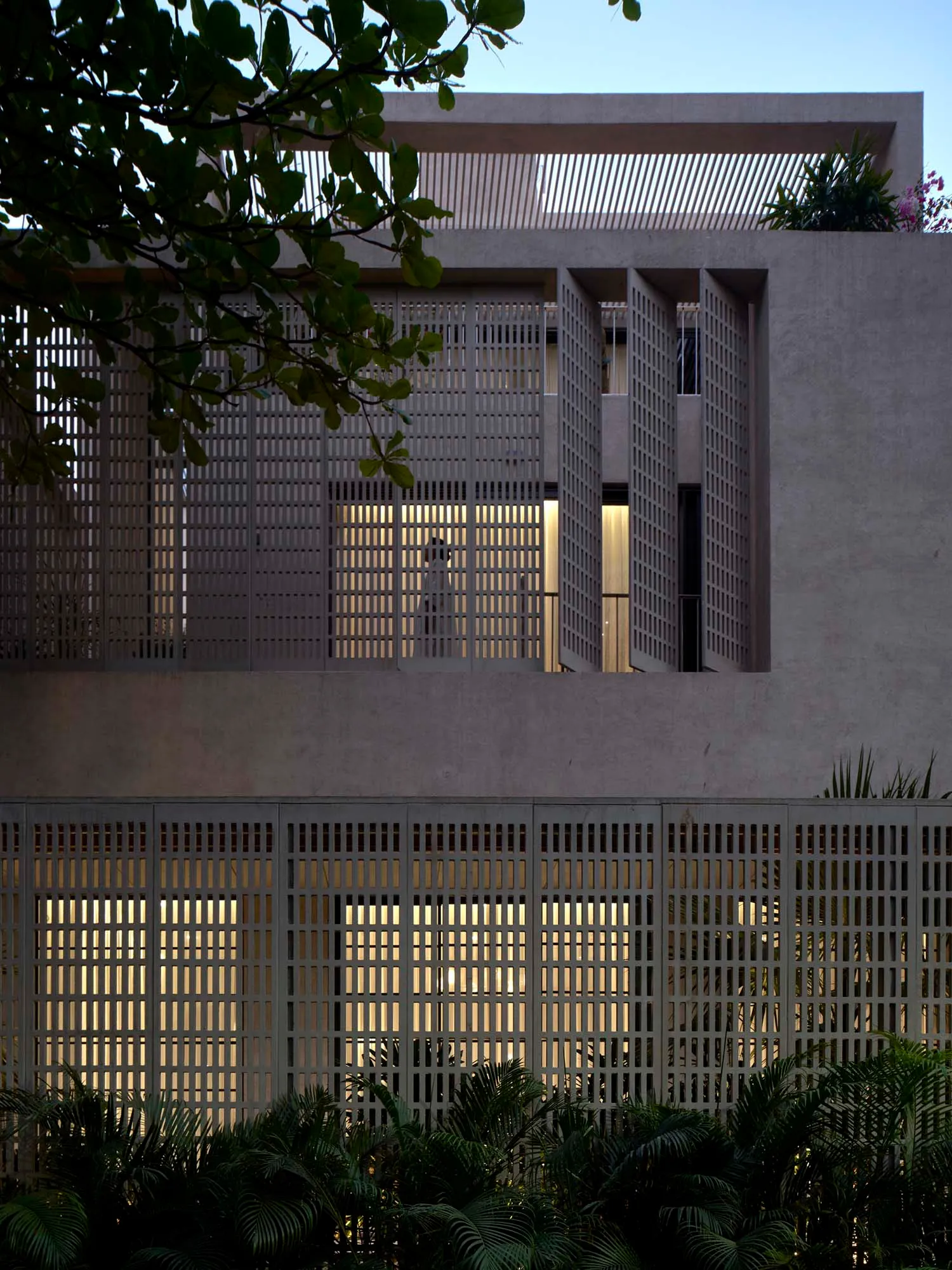 Photograph of a modern building with a concrete exterior, large window, and natural light