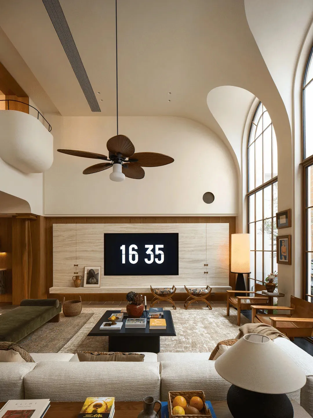 A well-lit living room with modern furniture, a TV, and decorative items, set against a neutral background with natural light from windows