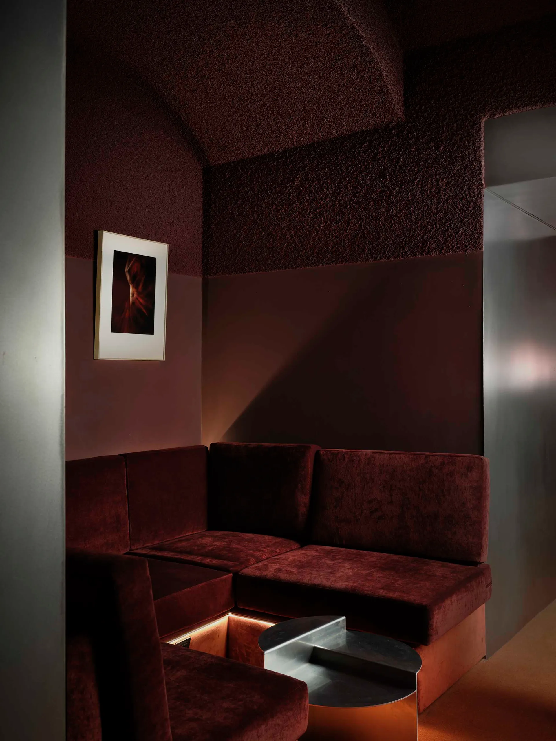 Cozy living room with a brown couch, a chair, and a table, dimly lit for a relaxing atmosphere