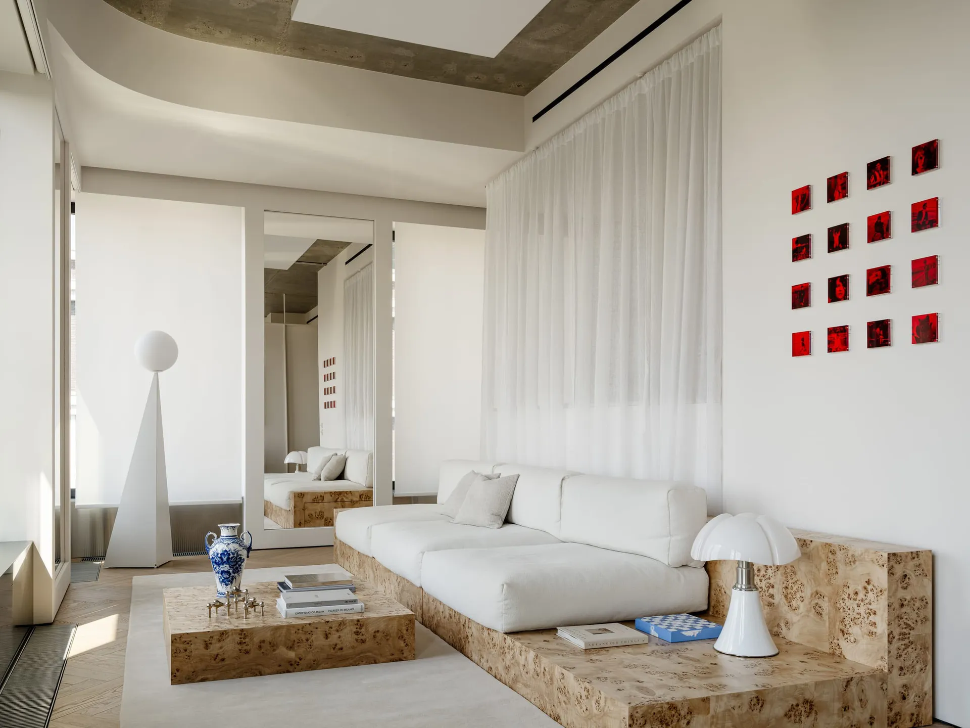 A well-lit living room with a white couch, coffee table, chair, and lamp, creating a comfortable and inviting atmosphere