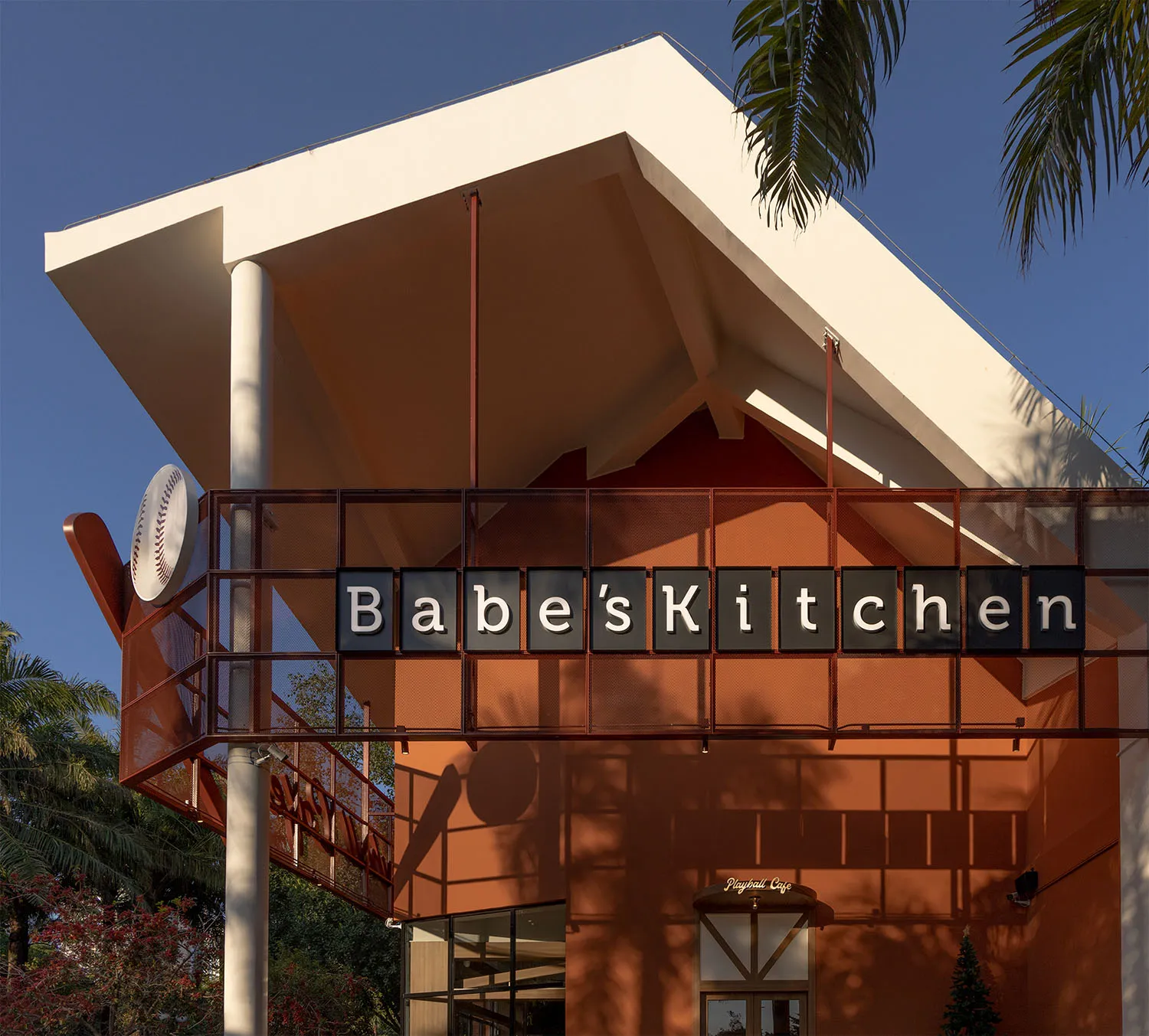 A casual restaurant with a modern architectural style, featuring a red roof, orange and white colors, and a dining table and chairs in a warm and inviting space with natural light