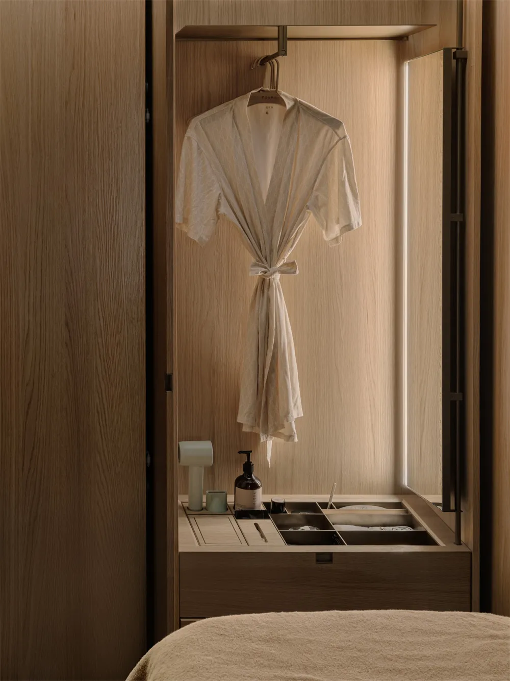 Bathroom with a wooden cabinet, white robe, and natural ambiance