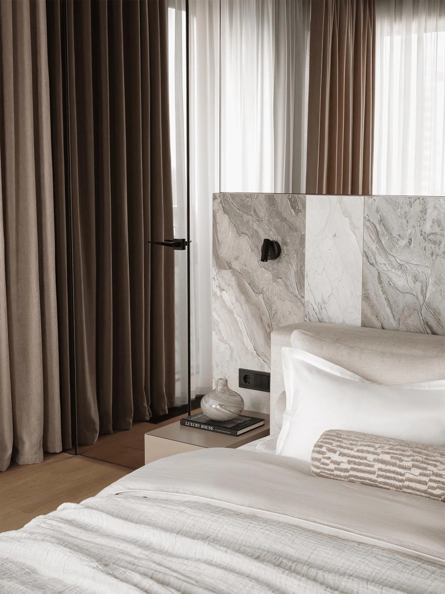 Bedroom with a bed, nightstand, and marble wall, featuring a modern and elegant style
