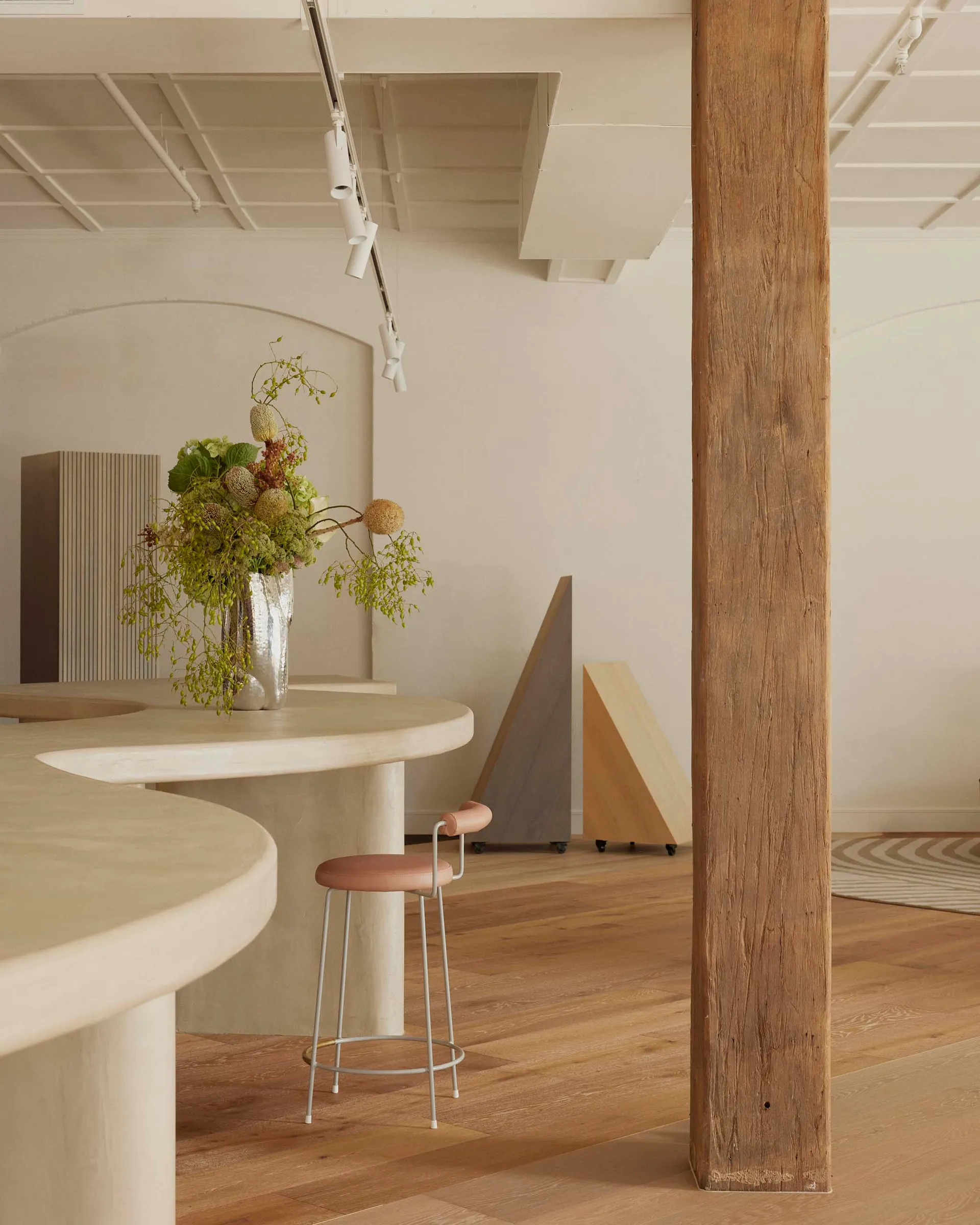 Cozy living and dining area with a wooden floor, a bar, a dining table, and a potted plant