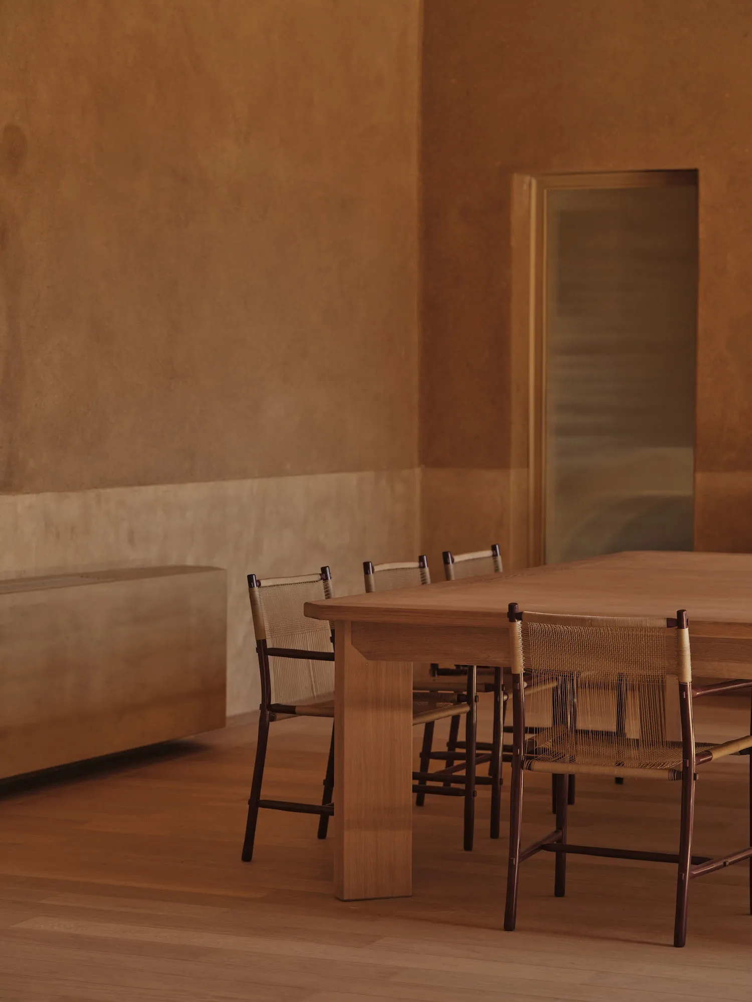 Cozy dining room with a wooden table and chairs, surrounded by a couch and dimly lit
