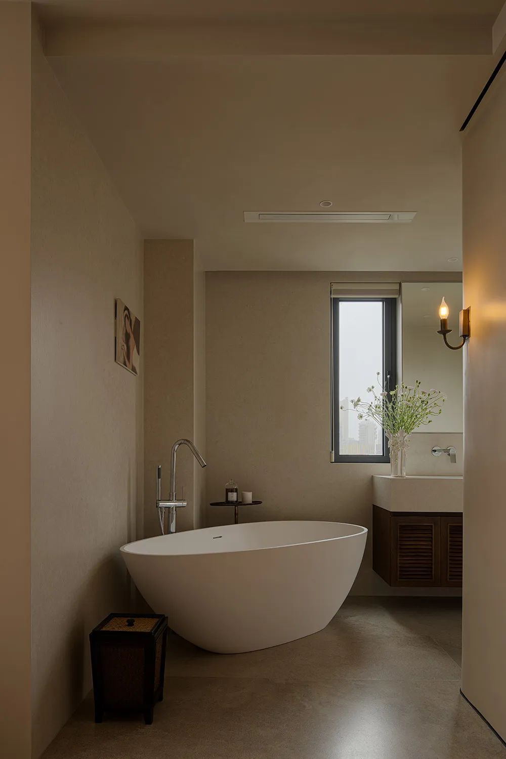 A modern bathroom with a large, white, round bathtub under a window, surrounded by a clean and well-lit space