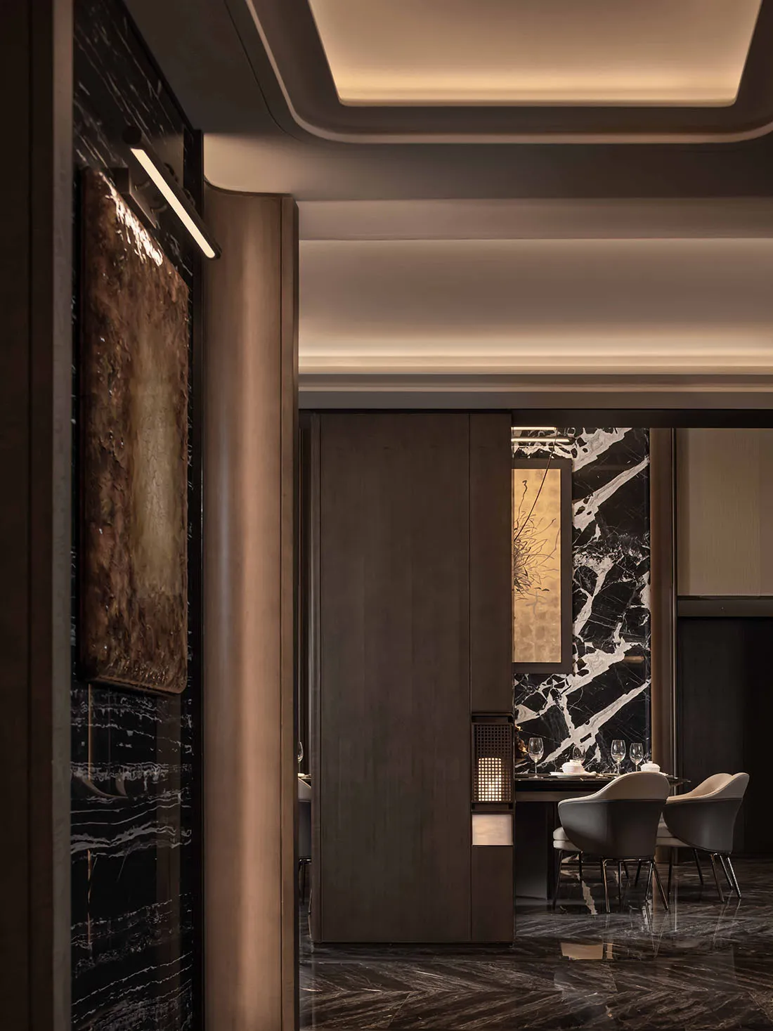 A modern restaurant interior with wood and marble surfaces, soft warm lighting, and comfortable seating for guests