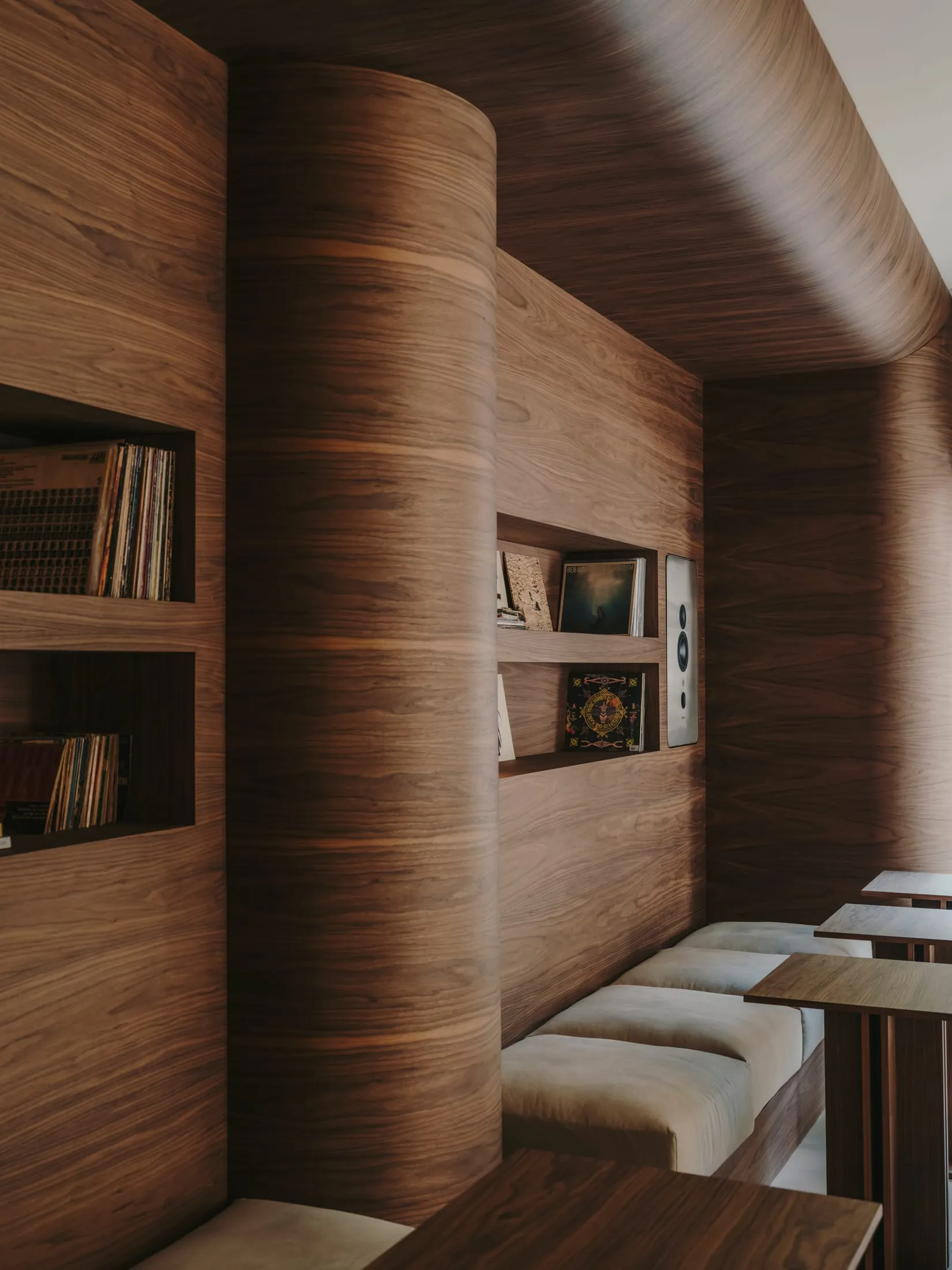 Cozy living space with wooden walls, a wooden bench, and books scattered around the room, creating a warm and inviting atmosphere