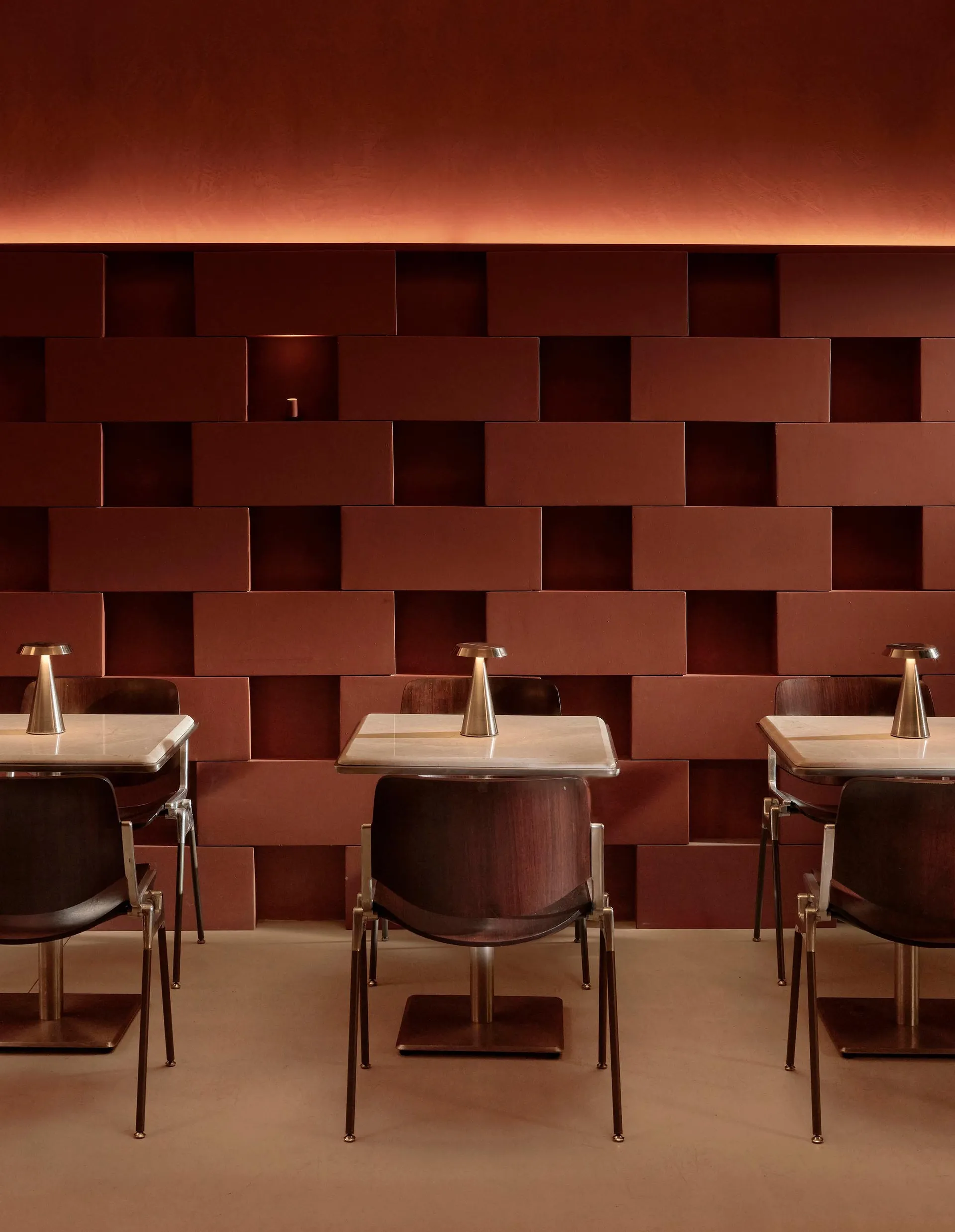 Warm and inviting restaurant with red brick walls, brown decor, and table lamps