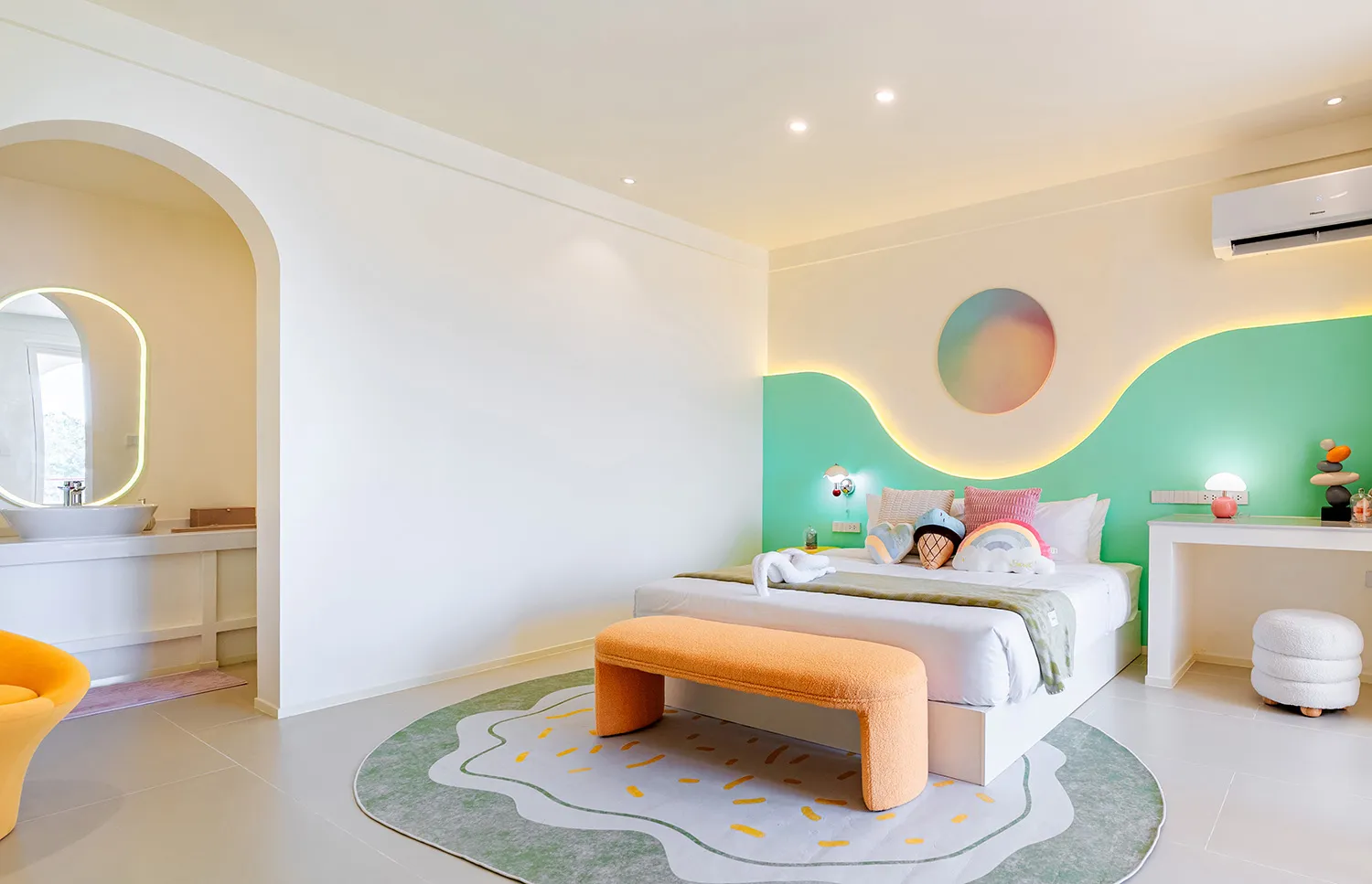 Cozy bedroom with a bed, bench, and chair, featuring a green and white color scheme and wooden accents