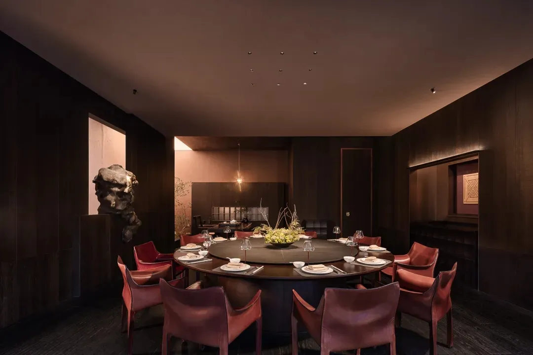 餐廳的圓桌、木地板和自然光線通過窗戶、餐具、酒杯和花瓶