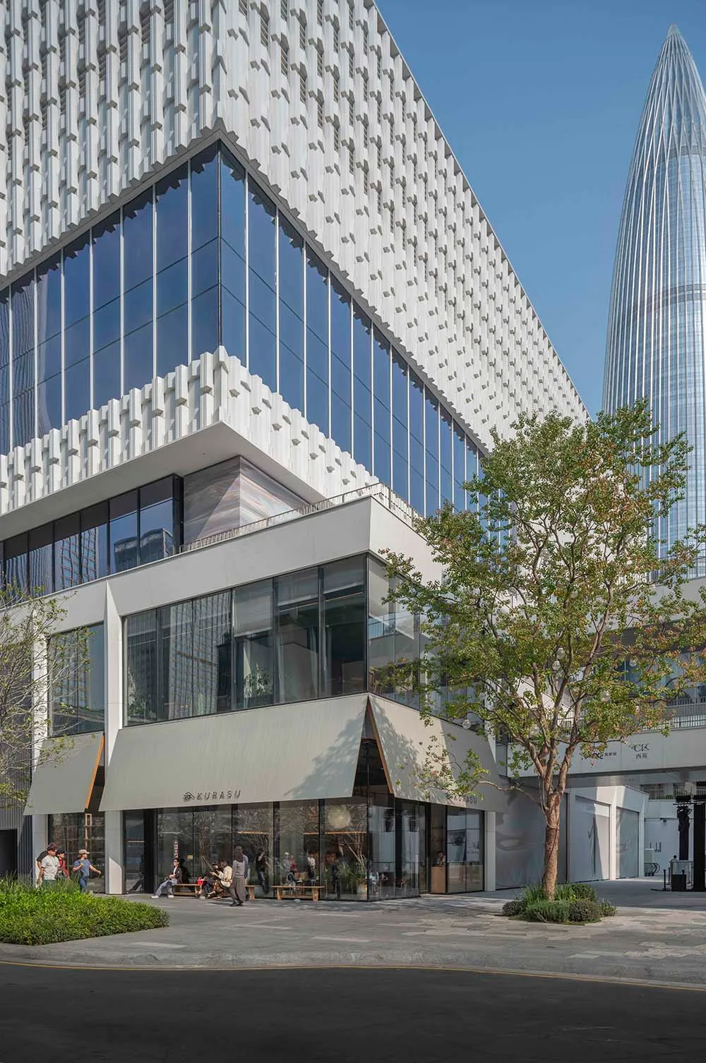 Large modern building with a sleek glass facade, well-lit by natural light from the windows
