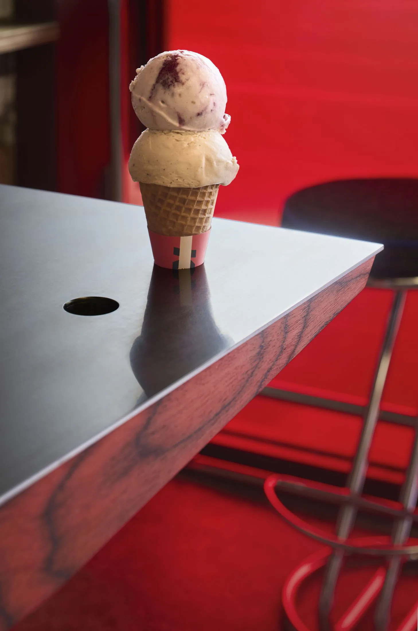 A red table with a white cupcake on top, set against a plain background