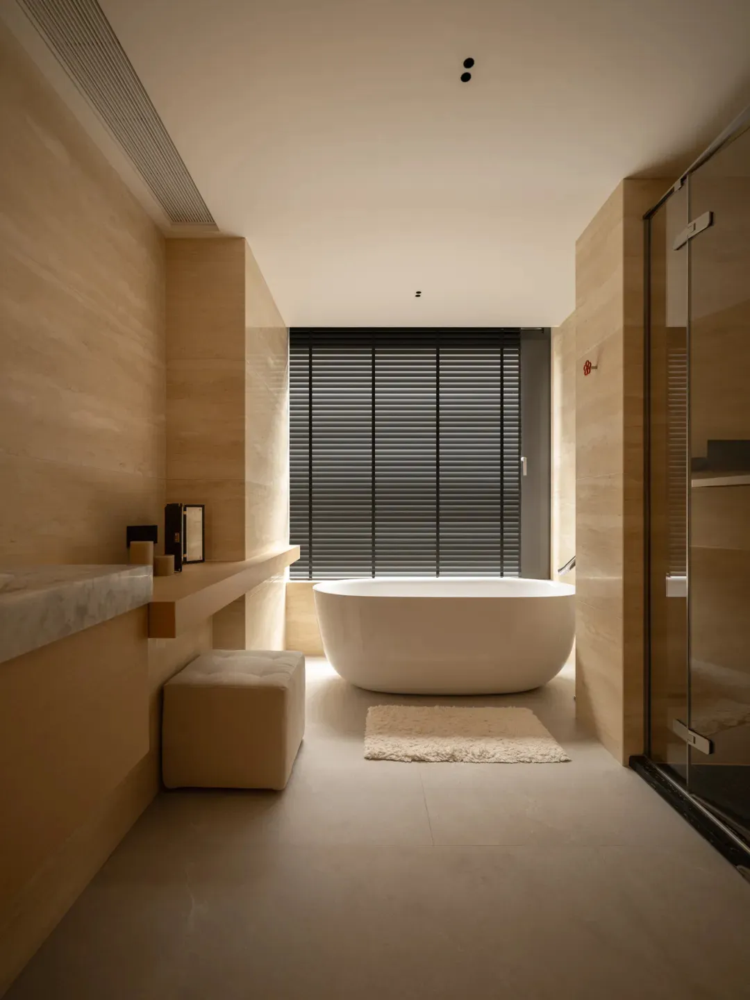 A bathroom with a white bathtub, sink, and toilet, set against a wooden floor and well-lit for a clean and inviting atmosphere
