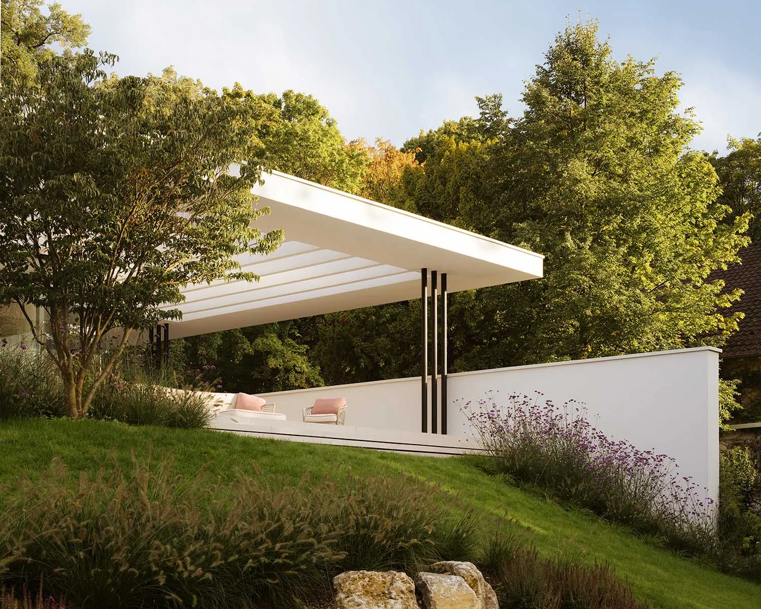A modern house with a white exterior, situated on a hillside, surrounded by lush greenery and trees, with a large patio and a white roof