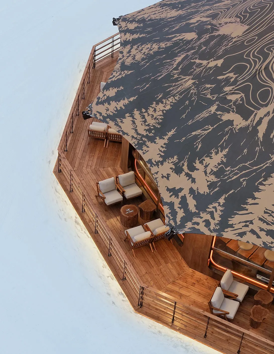 A wooden structure with a large open umbrella providing shade and protection, featuring a dining table and chairs in a social and inviting setting
