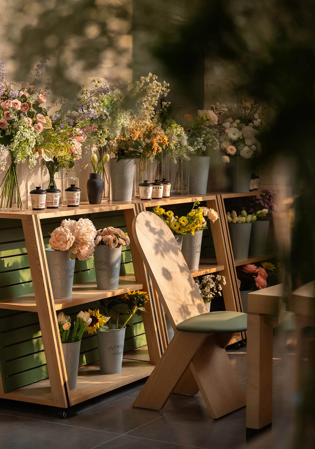 A modern living-dining space with a wooden floor, potted plants, vases, and bottles, featuring a cozy and inviting atmosphere with soft warm lighting