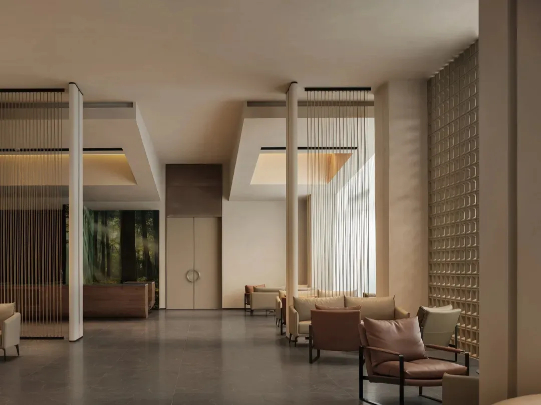 A modern lobby with several chairs arranged for conversation, near a large window with natural light and a clean, minimalist design