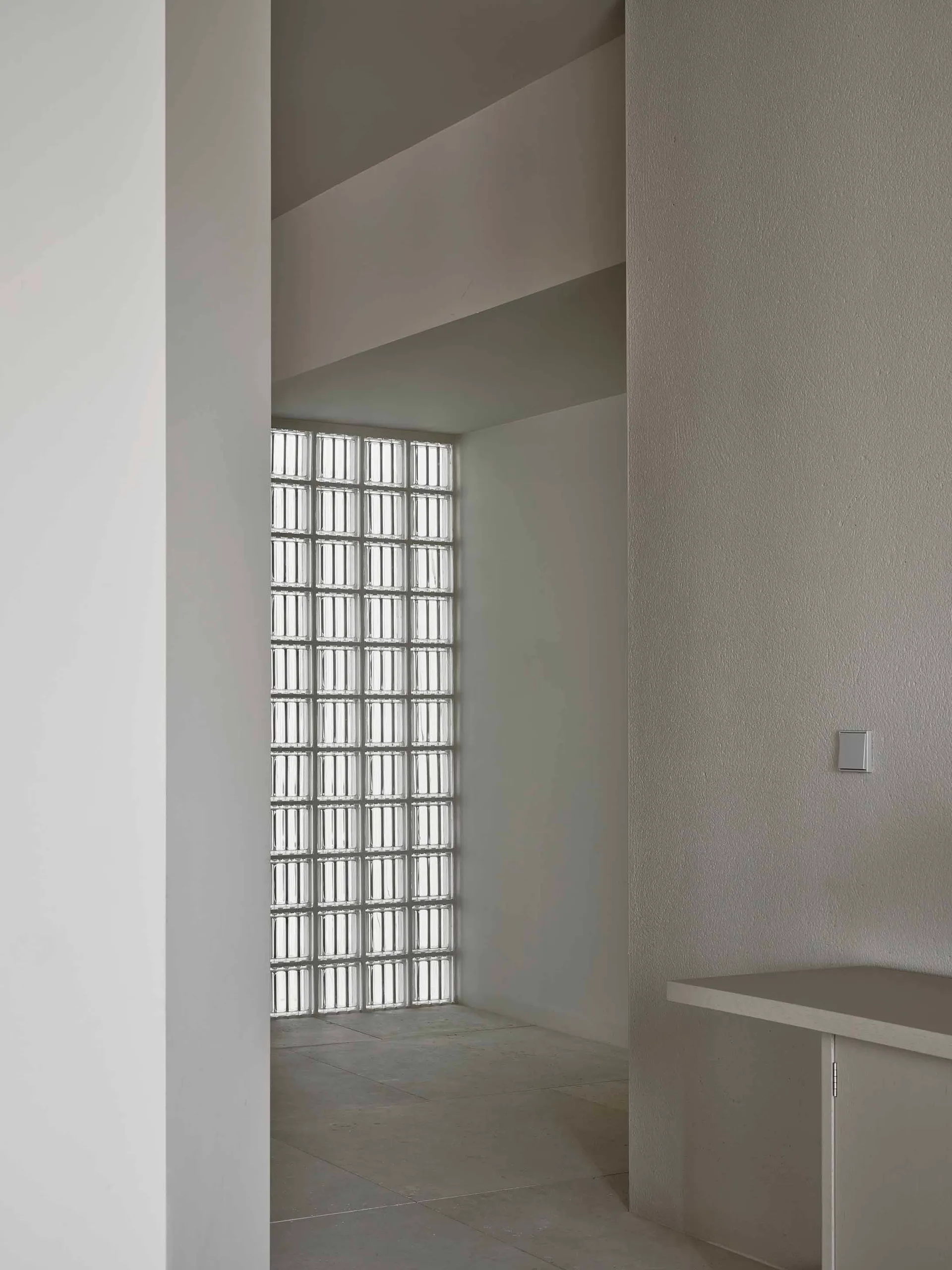 Small, minimalist room with a white wall and window, featuring a window sill