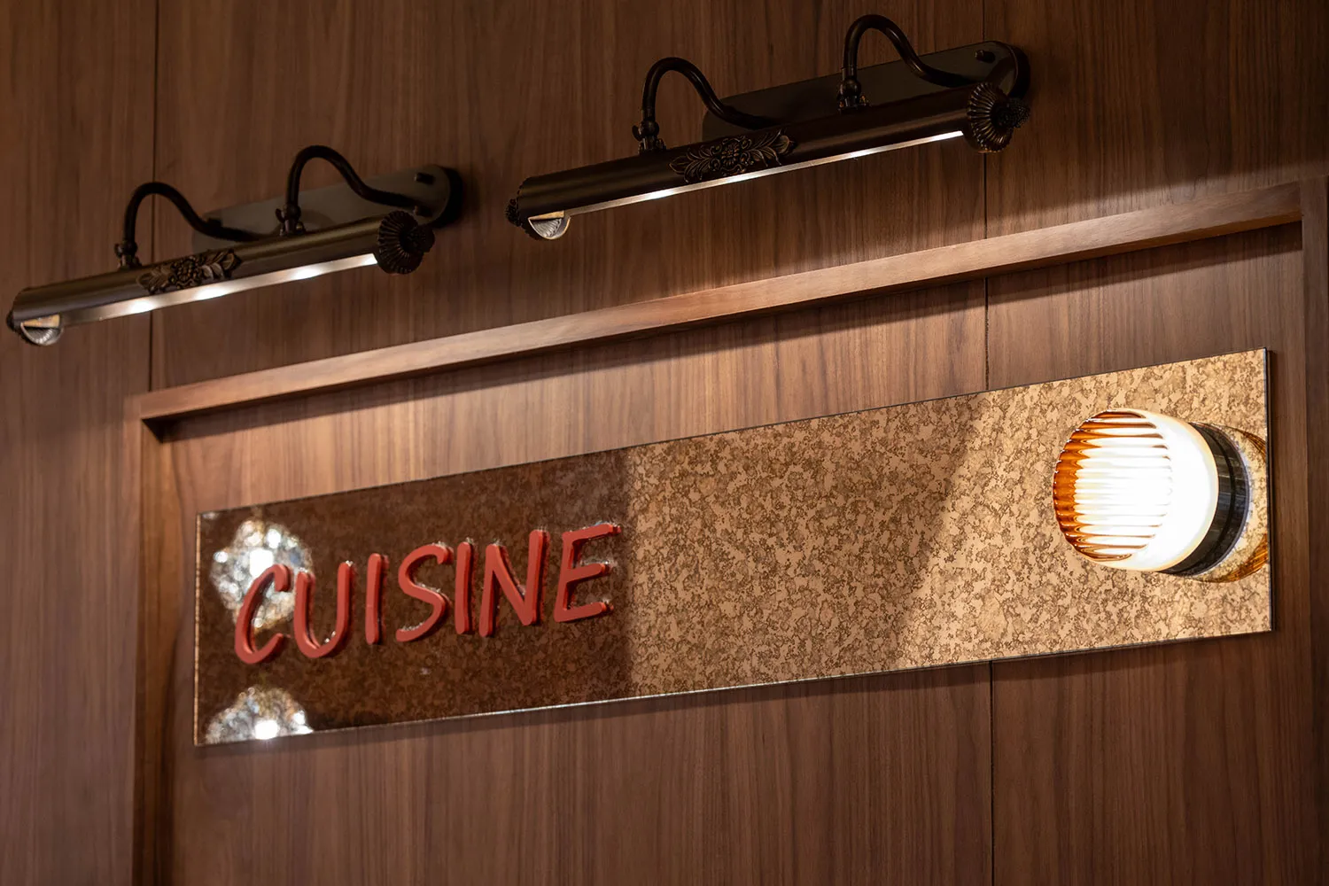 A well-lit restaurant with a wooden sign reading Cuisine, creating a warm and inviting atmosphere