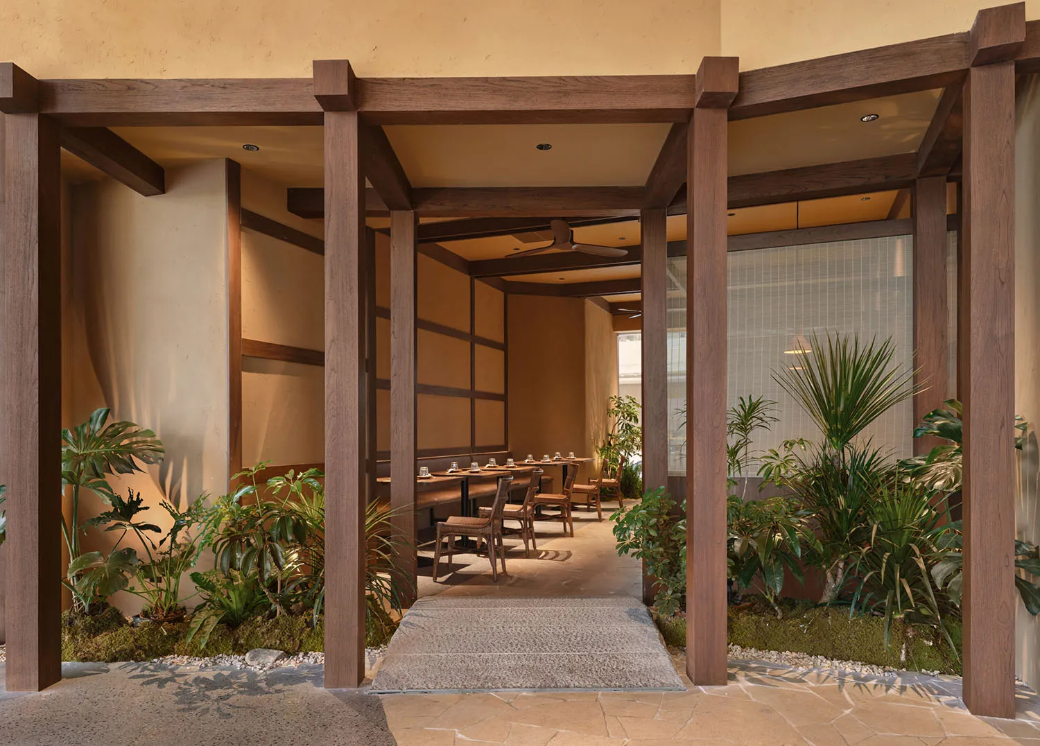 A modern restaurant interior with a wooden floor and ceiling, decorated with potted plants and furnished with chairs and dining tables