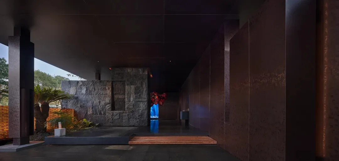 Cozy room with stone walls, a wooden floor, and a stone staircase, lit by dim lighting