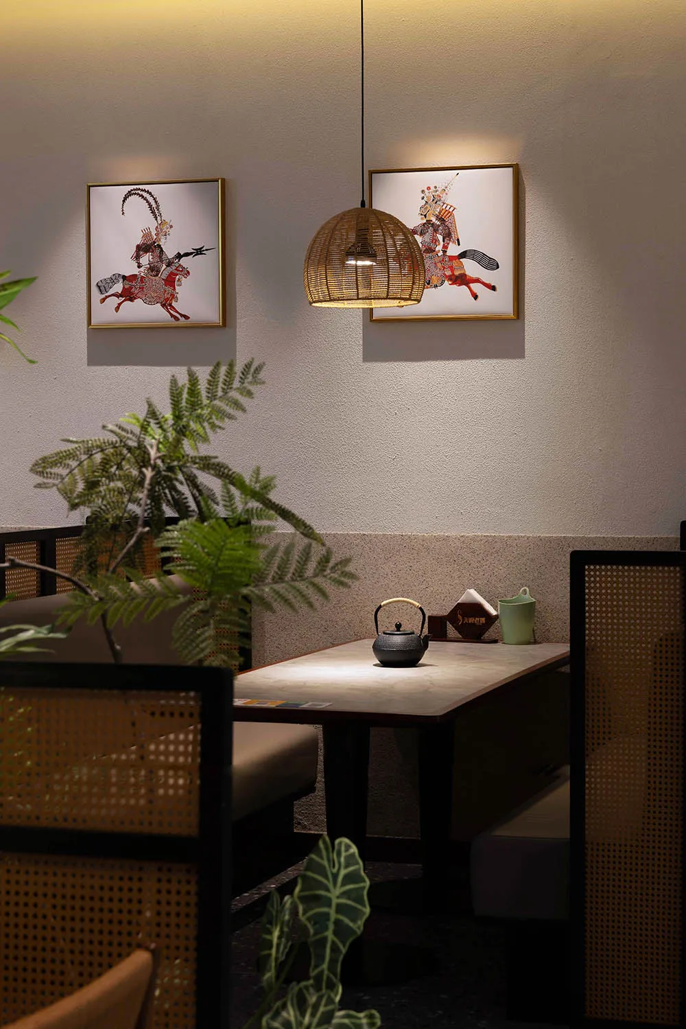 A well-lit restaurant with a dining table, chairs, a potted plant, and a vase, creating a cozy and inviting atmosphere