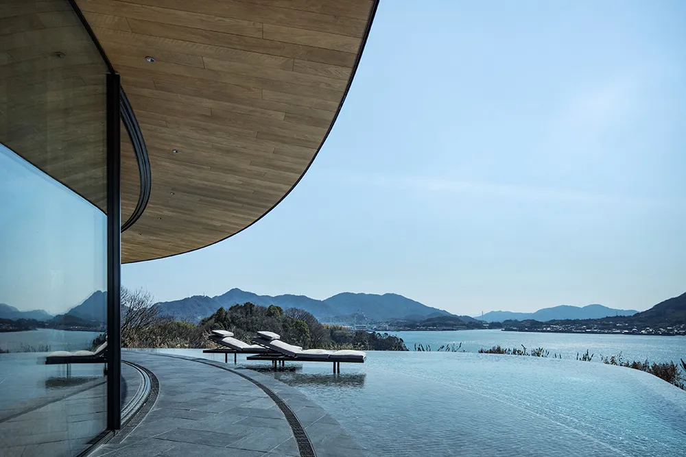 A modern house with a large pool and a wooden deck, surrounded by a wooden deck and a wooden wall