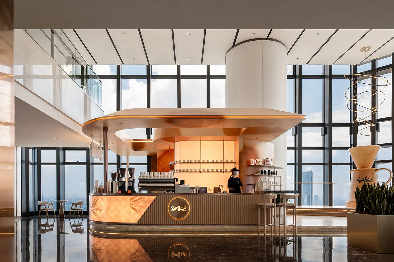 A cozy coffee shop with a wooden counter, cups, and bottles, and a person serving customers