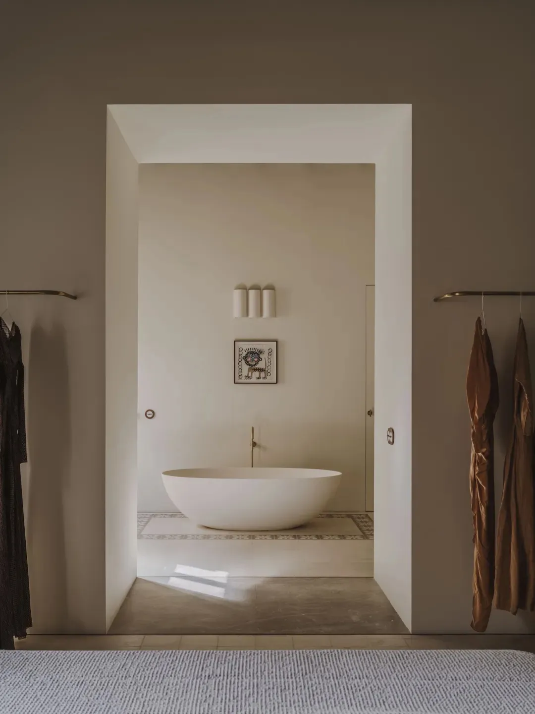 A well-lit bathroom with a white bathtub and doorway, surrounded by a predominantly white space with a calm and relaxing atmosphere