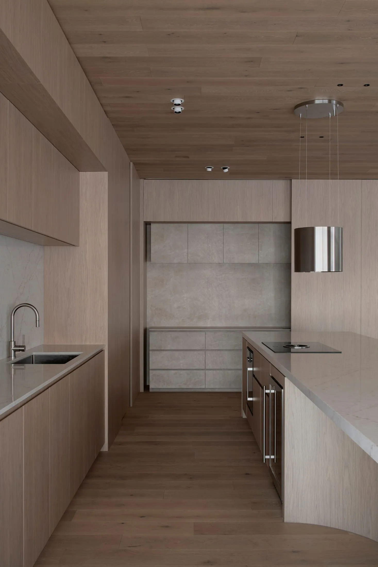 Warm and elegant kitchen with wooden cabinets, marble countertop, sink, oven, and refrigerator, dim lighting creating a cozy atmosphere