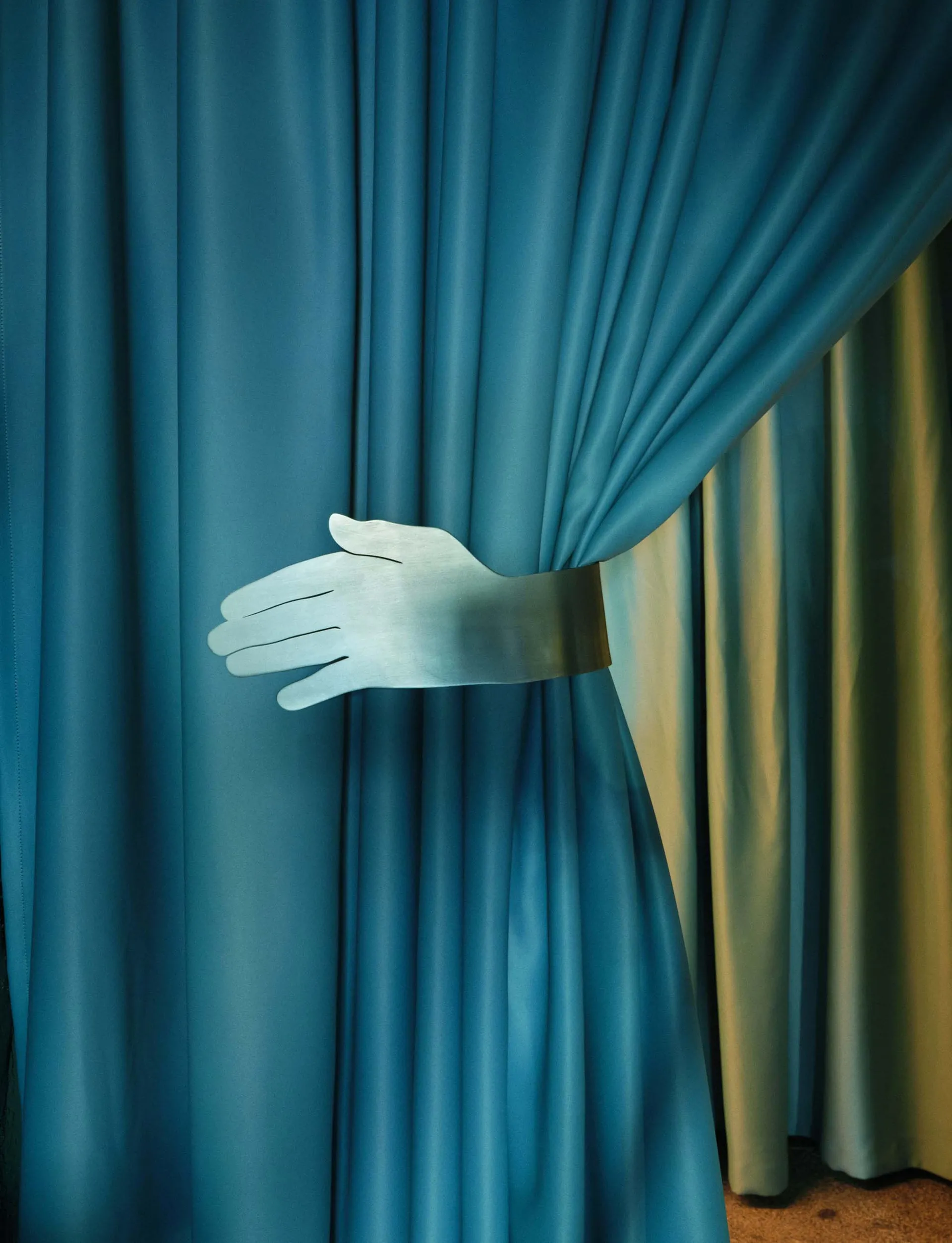 A blue curtain with a white-gloved hand waving from behind it, creating a mysterious and intriguing scene