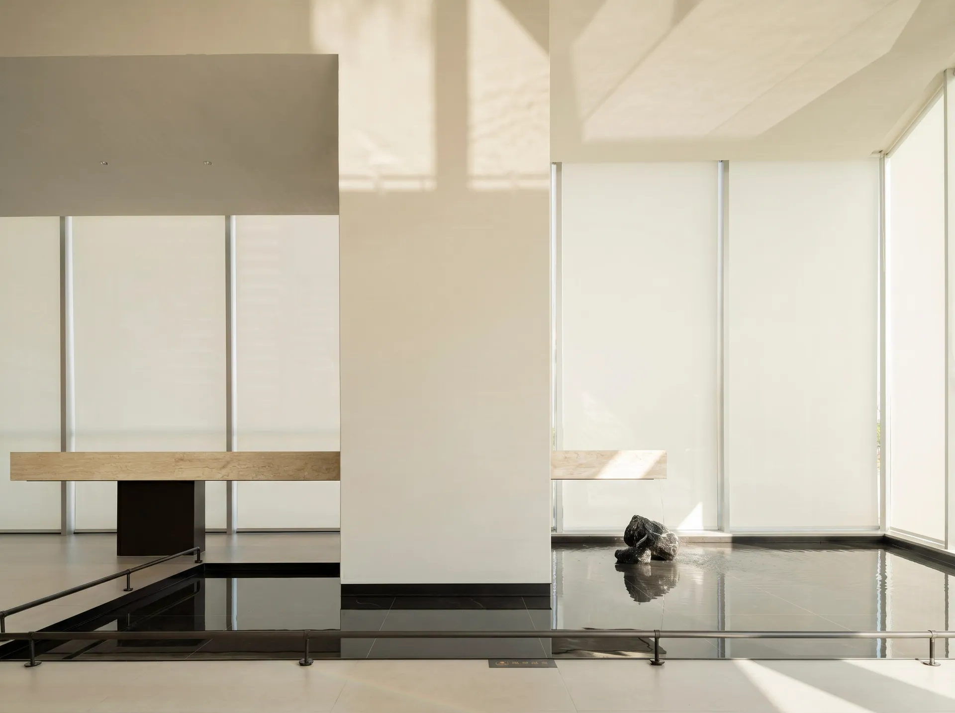 A calm and inviting living room with a black floor, white wall, and natural light from the windows, featuring a modern bench and a dog sitting on it