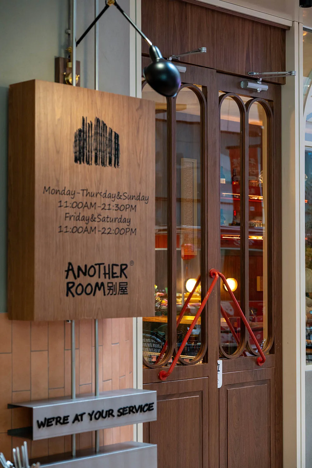 A dimly lit restaurant with modern furniture and a wooden door, creating a cozy atmosphere