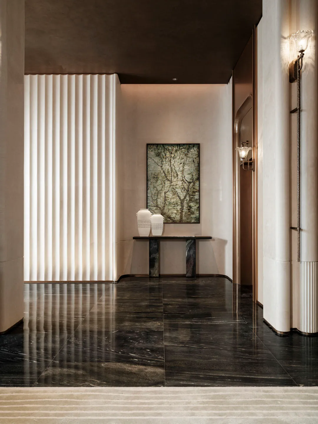 A well-lit modern hallway with a marble floor, white walls, a large painting, and decorative vases