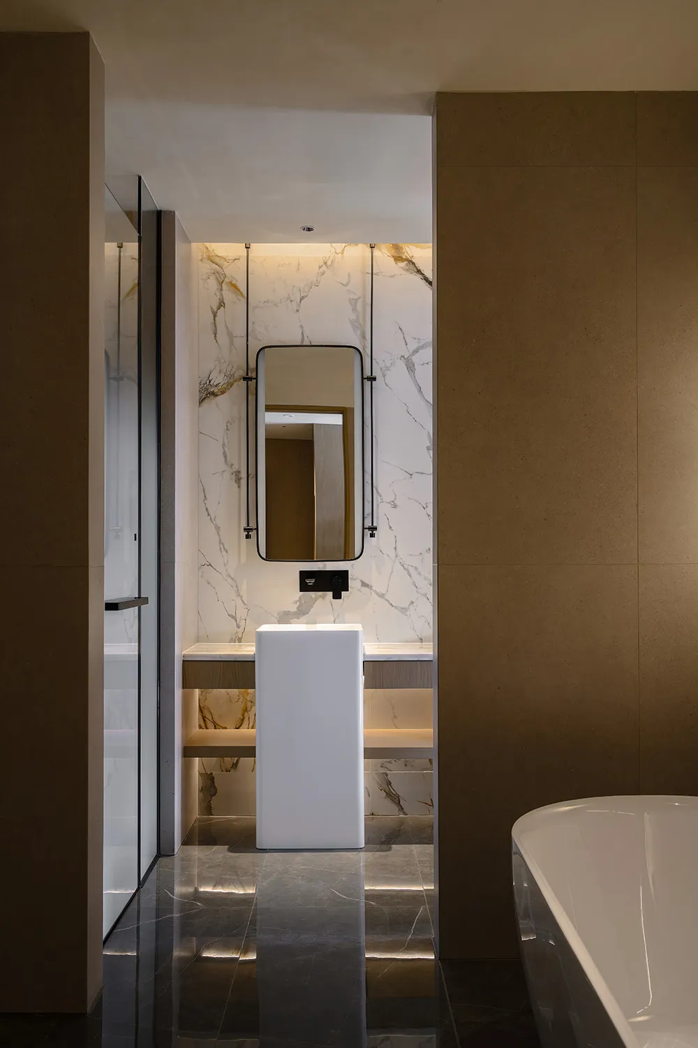 Bathroom with a white bathtub, toilet, marble countertop, and sink, set against a brown wall with dim lighting