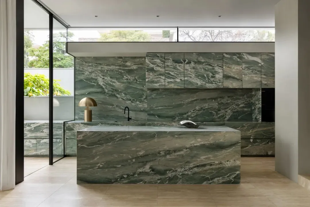 Bright and inviting modern kitchen with a marble countertop, natural light, and a sink