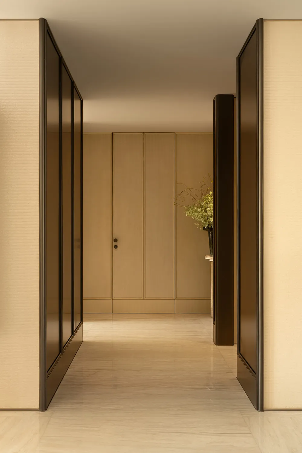 A well-lit hallway with a wooden door and cabinet, creating a warm and inviting atmosphere