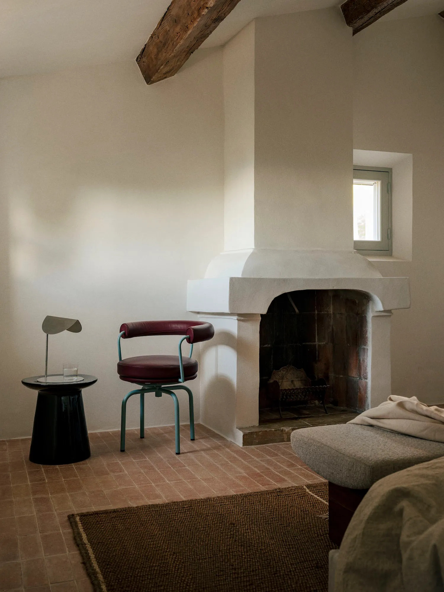 Cozy living room with a white interior, a fireplace, a couch, a chair, and a dining table, creating a warm and inviting atmosphere