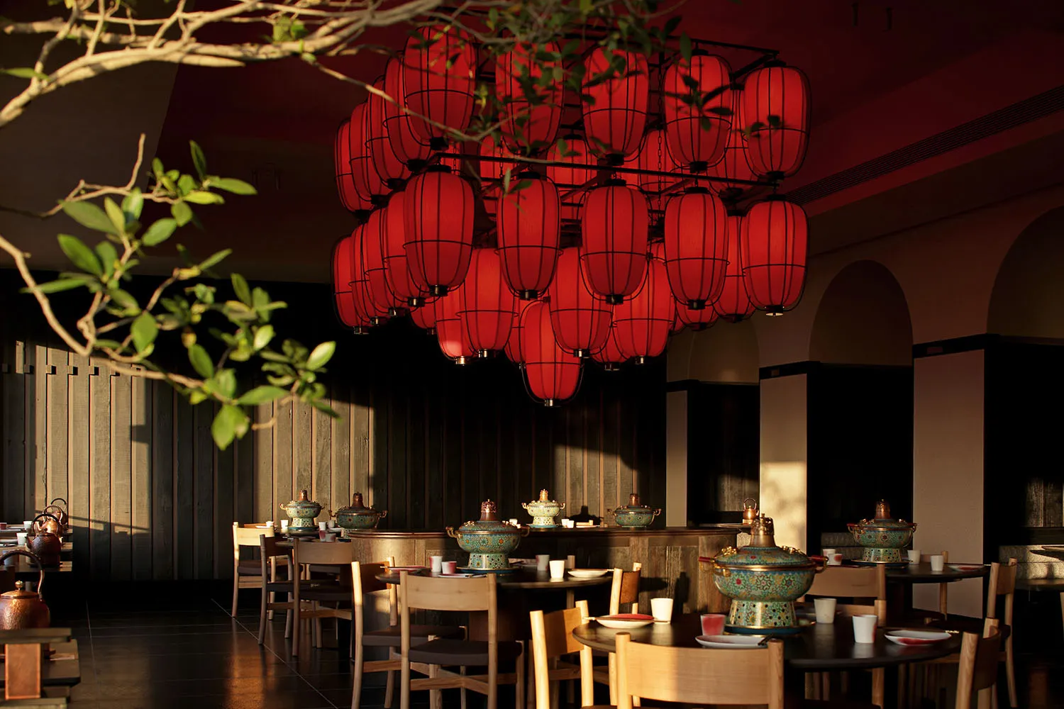 A modern dining space with a wooden floor, a dining table, and chairs, set with various bowls and cups, in a warm and welcoming atmosphere