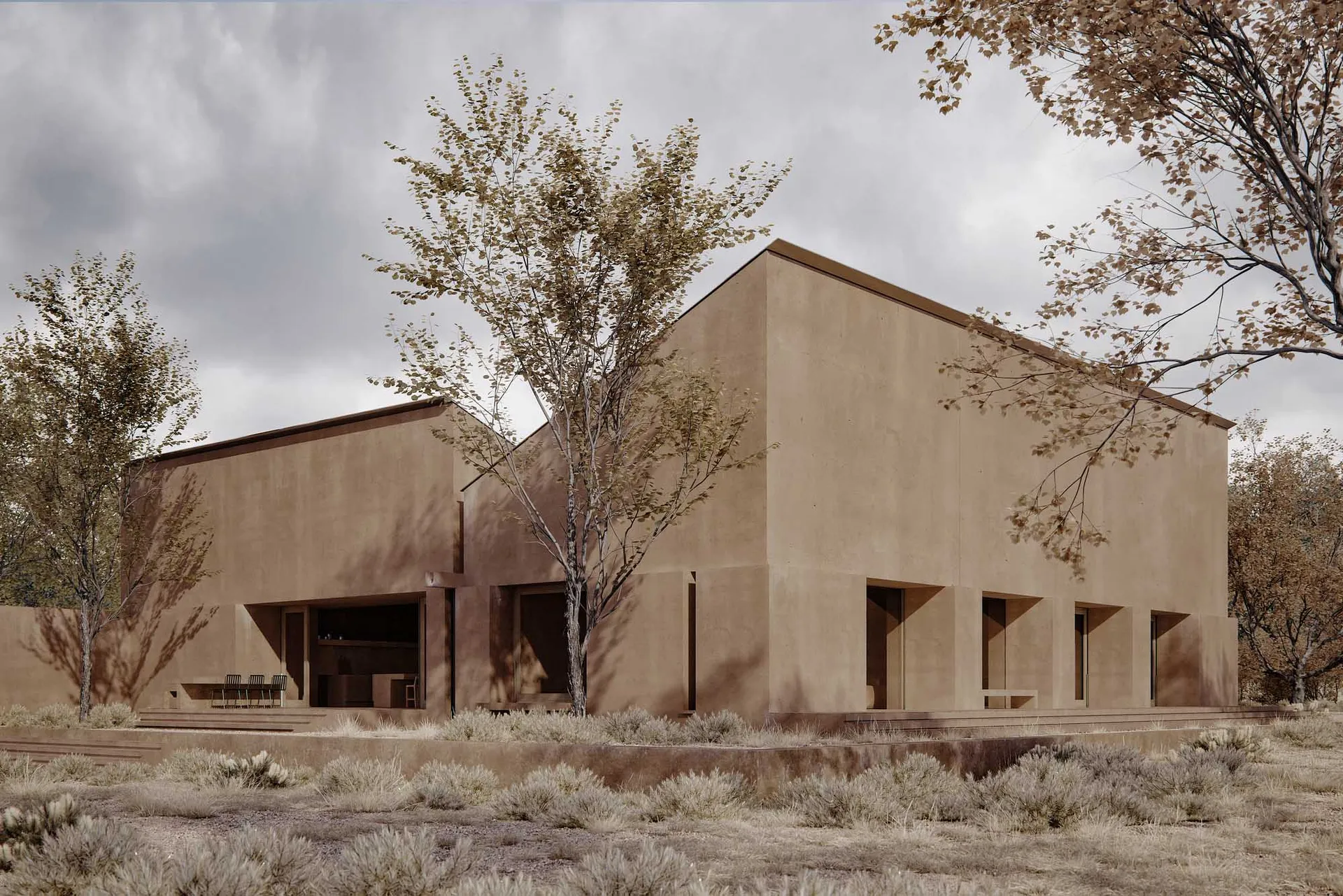 A stone building with a large window and door stands in a desert landscape with a single tree in front