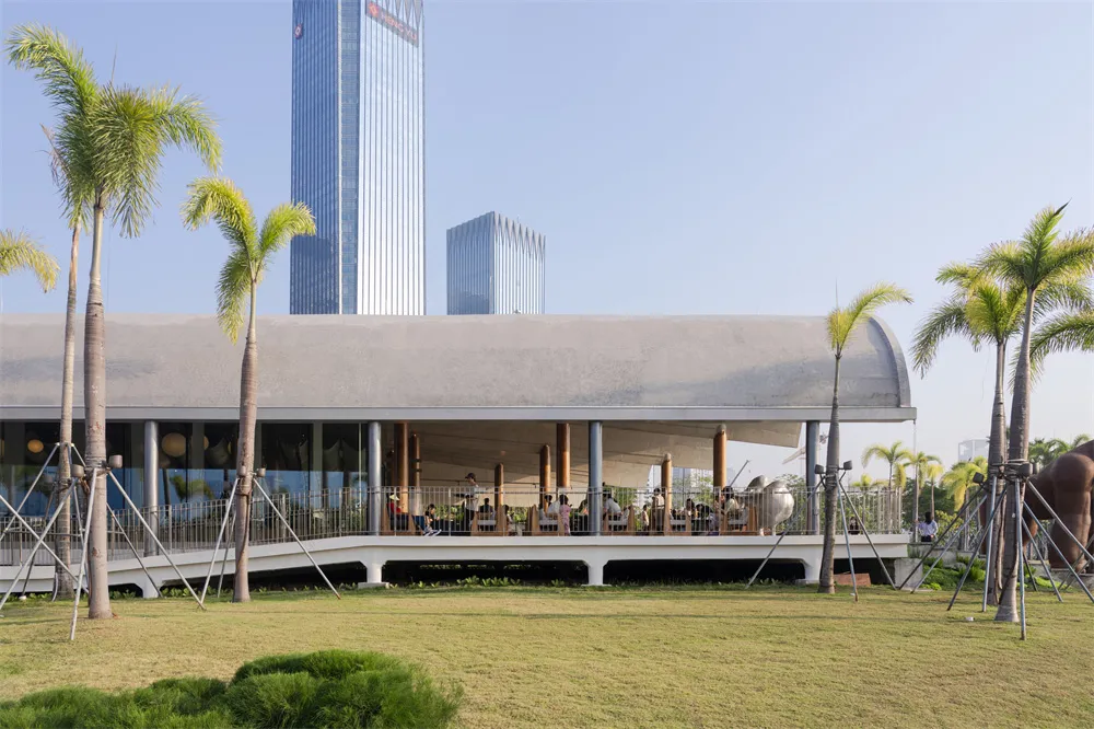 一間空間廣敞的現代餐廳區域，配備大桌子和椅子，位於一間有自然光線照進的時尚及功能性的建築中
