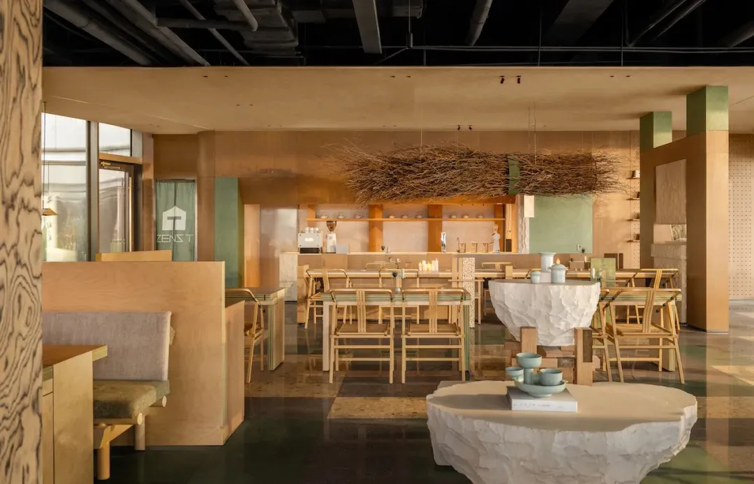 A modern restaurant with a wooden floor, several chairs, and dining tables, featuring soft lighting and a comfortable seating arrangement