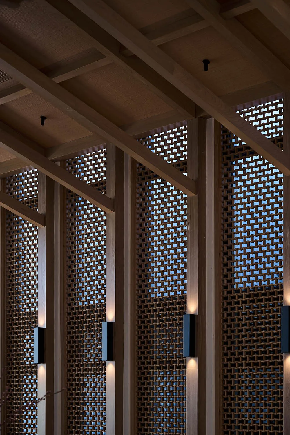 A large room with a wooden ceiling and wooden beams, featuring multiple windows for natural light and a cozy atmosphere