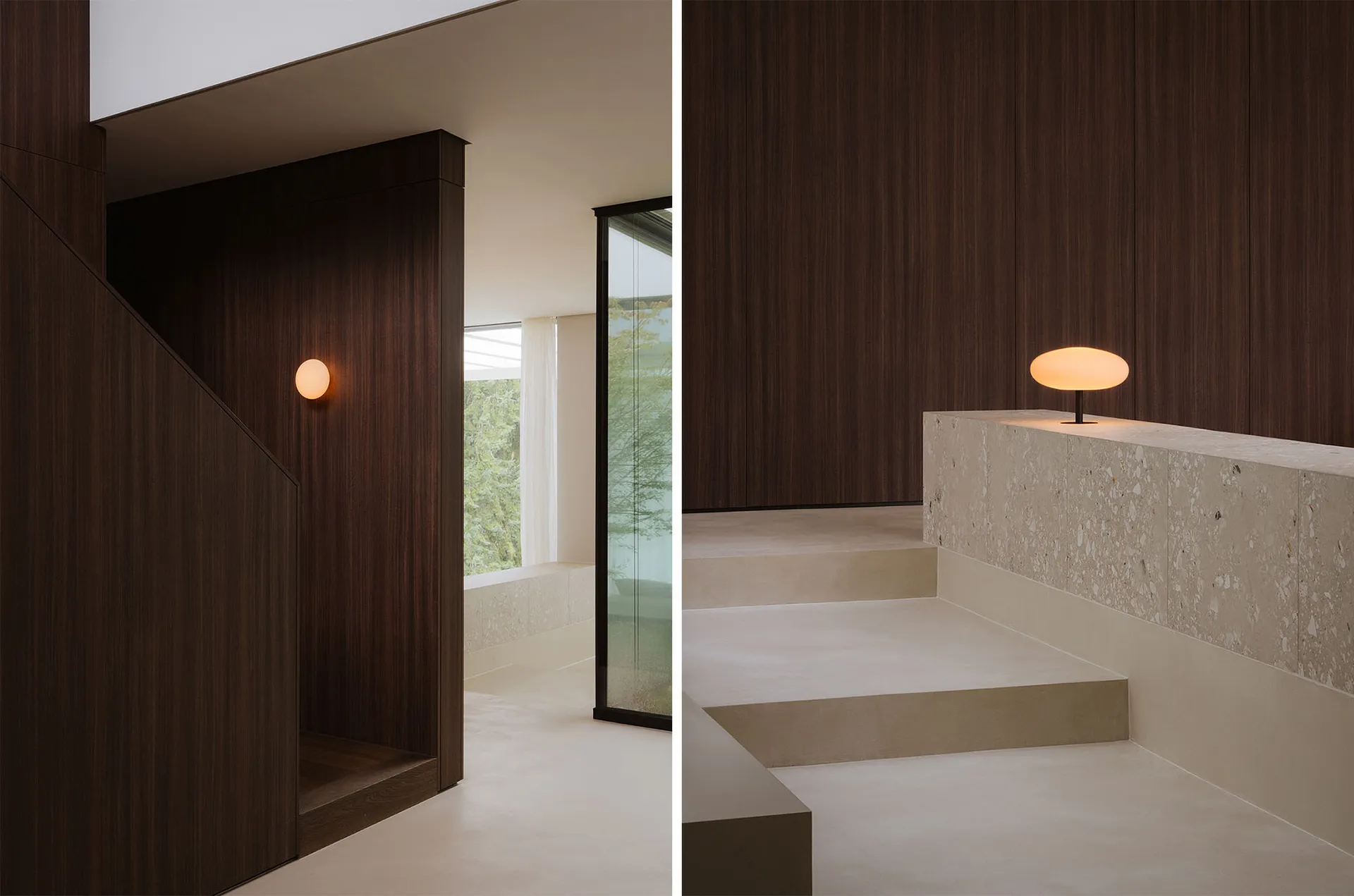 Dimly lit bathroom living space with a wooden floor, stone wall, and a large window, featuring a staircase and a sink