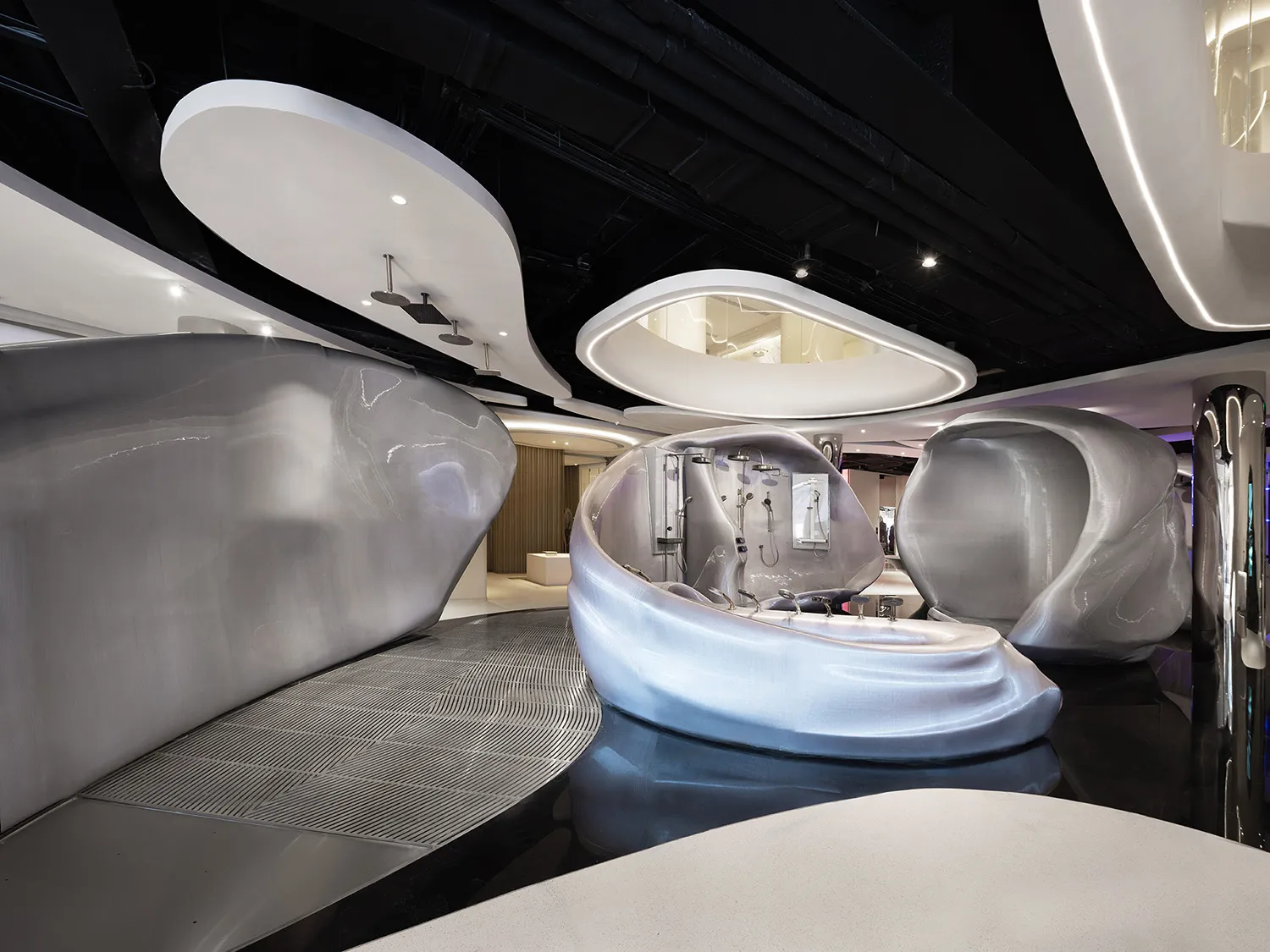 A modern room with a curved wall, glass, and metal, filled with natural light and featuring a sleek, open design